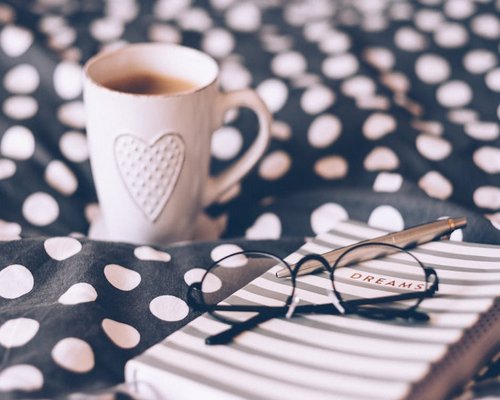 Person establishing a morning routine with glass of water and notebook